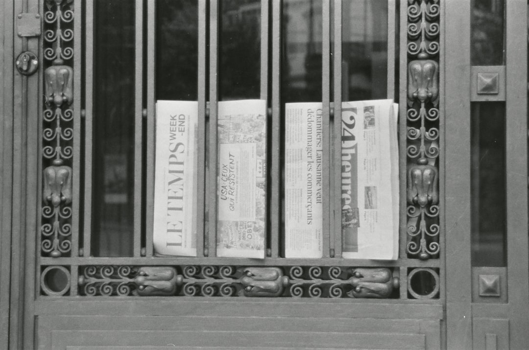 Newspapers behind ornate metal gate