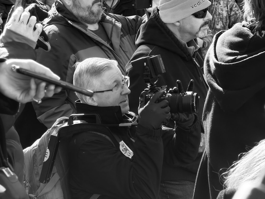 Man in crowd taking photos with dslr camera