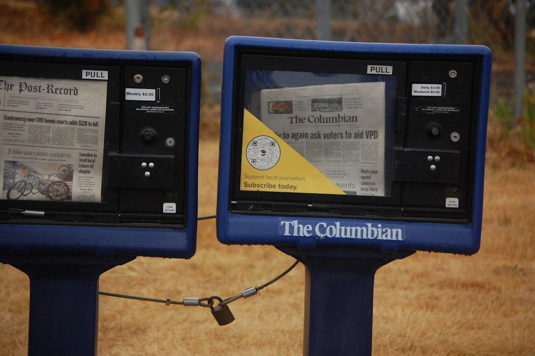 Two blue newspaper stands with newspapers inside