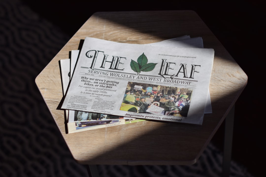 A copy of The Leaf newspaper on a wooden table in bright sunlight