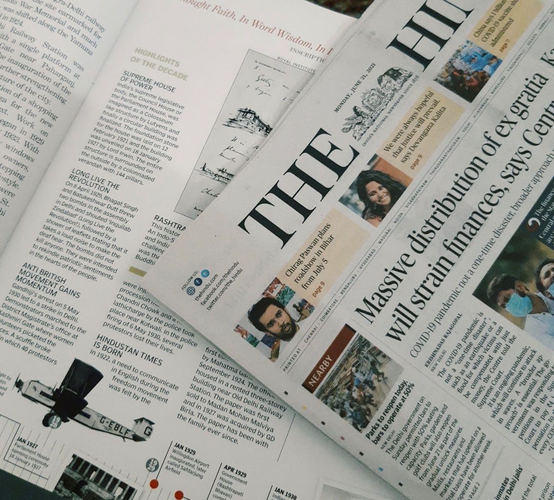 A copy of The Hindu newspaper featuring articles and photographs on a white surface